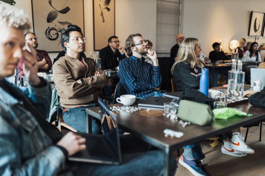pexels photo 18999176 Diverse group of adults attending an educational seminar, focused on a presentation inside a modern conference room.