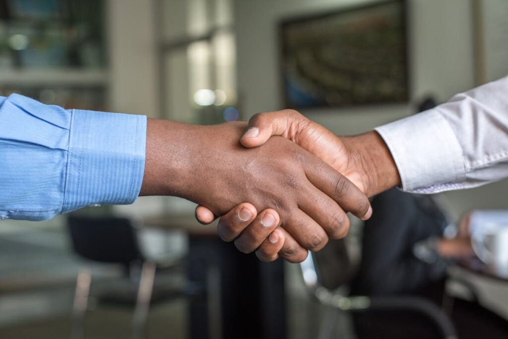 pexels photo 955395 Close-up of two men's handshake symbolizing agreement in an office.